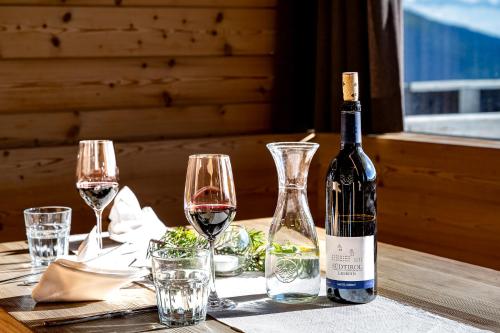 a bottle of wine sitting on a table with glasses at Starkenfeldhütte in Rodengo