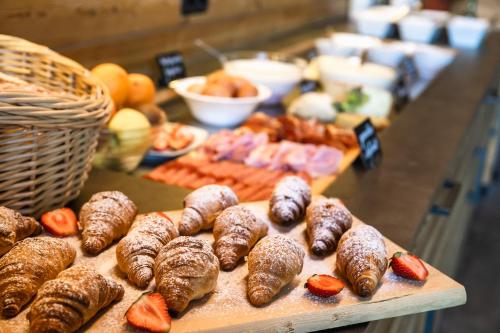 a table topped with pastries and strawberries and other foods at Starkenfeldhütte in Rodengo