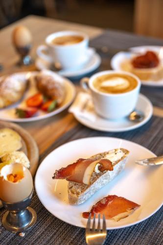 a table with plates of food and cups of coffee at Starkenfeldhütte in Rodengo