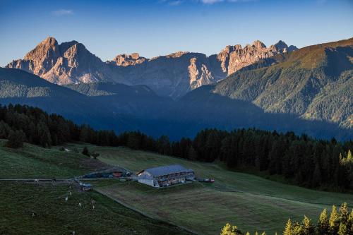 a house on a hill with mountains in the background at Starkenfeldhütte in Rodengo