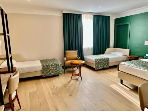 una habitación de hotel con 2 camas y una silla en Relais La Fattoria, en Melfi