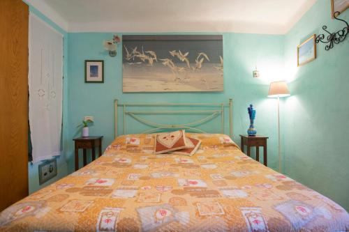 a bedroom with a bed with a quilt on it at HelloElba Appartamento Il Borgo in Marciana