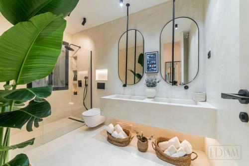 uma casa de banho com uma banheira, um WC e 2 espelhos em ELITE SUITE by EdSam, In Madrid em Madrid