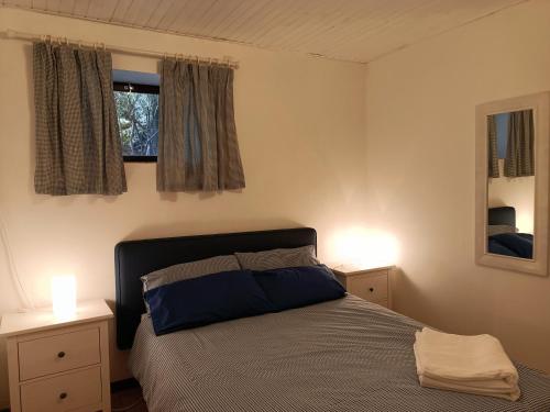 1 dormitorio con 1 cama con 2 mesitas de noche y 2 ventanas en Gîtes Périgord Rocamadour Sarlat Gourdon naturiste de juin à sept, en Salviac