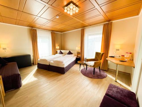 ein Hotelzimmer mit einem Bett und einem Schreibtisch in der Unterkunft City Hotel Ost am Kö in Augsburg