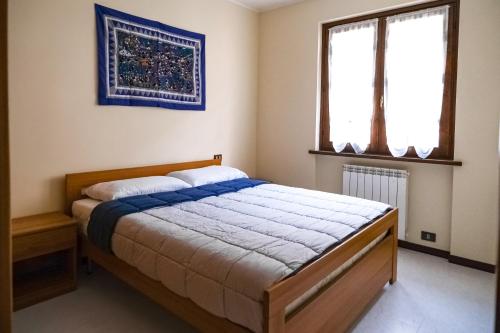 una camera con letto e finestra di La Quiete - Casa Vacanza a Ranzanico