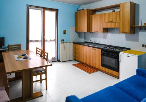 una cucina con tavolo e piano cottura forno superiore di La Quiete - Casa Vacanza a Ranzanico