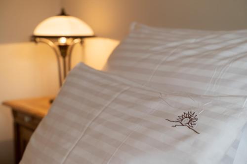 a close up of a white bedsheet with a flower on it at Pension Slunečnice & Panorama Restaurace Farma in Špindlerův Mlýn