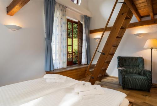 a bedroom with a bed and a ladder and a chair at Pension Slunečnice & Panorama Restaurace Farma in Špindlerův Mlýn