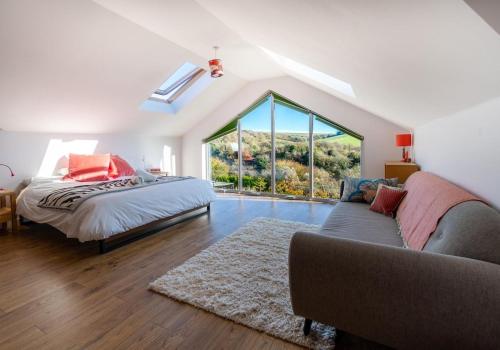 1 dormitorio con cama, sofá y ventana en Sussex Retreat with Free Parking for 4 Vehicles - By My Getaways, en Pyecombe