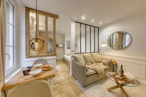 a living room with a couch and a table at Le Petit Paris - Cocon & Spa & Sauna in Chartres