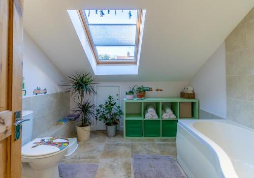 a bathroom with a toilet and a bath tub at Sussex Retreat with Free Parking for 4 Vehicles - By My Getaways in Pyecombe