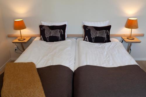 two beds in a room with two lamps on tables at Hotell Magasin 1 in Mörbylånga