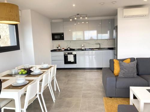 a kitchen and living room with a table and a couch at E1 Suites & Spa aparthotel style - Gym & Spa in Gibraltar