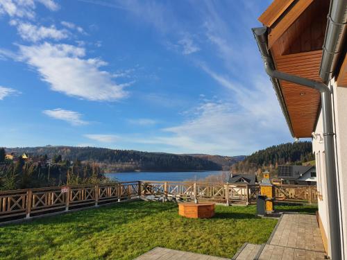 a view of a lake from the deck of a house at Dom Na Wzgórzu WODA na wyłączność JACUZZI SAUNA ROWERY in Zawóz