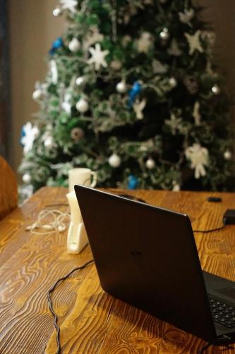 a laptop sitting on a table in front of a christmas tree at Hotel Elegant in Stepantsminda