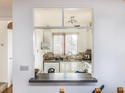 a kitchen with white cabinets and a sink at Pass the Keys Holiday Home Near Beaches in Chichester