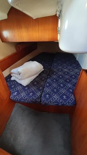 a bed in a boat with a white pillow on it at Námořní jachta Jeanneau Sun Odyssey 37.1 in Lipno nad Vltavou