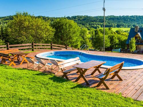 a picnic table and chairs next to a swimming pool at Gościniec Rabe - Agro&SPA in Ustrzyki Dolne
