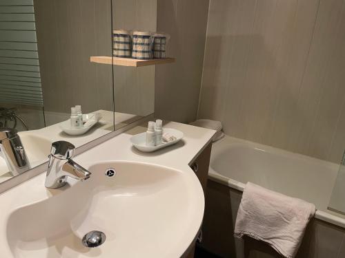 une salle de bain avec un lavabo et une baignoire dans l'établissement T2 30m2 plein centre, lit fait, linge fourni, WIFI, à Cauterets