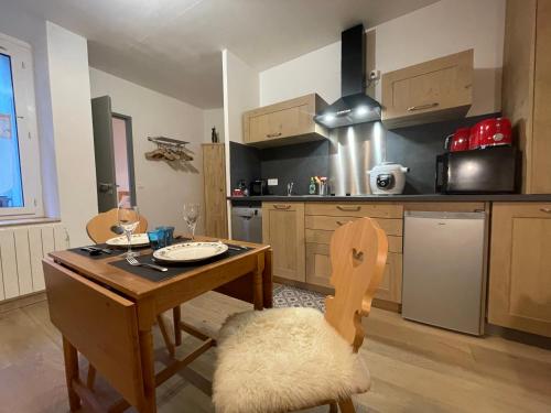 une cuisine avec une table en bois et une salle à manger dans l'établissement T2 30m2 plein centre, lit fait, linge fourni, WIFI, à Cauterets