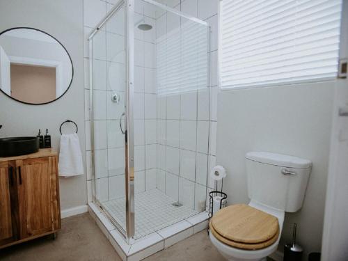 a bathroom with a shower with a toilet and a mirror at Lavender BnB in East London