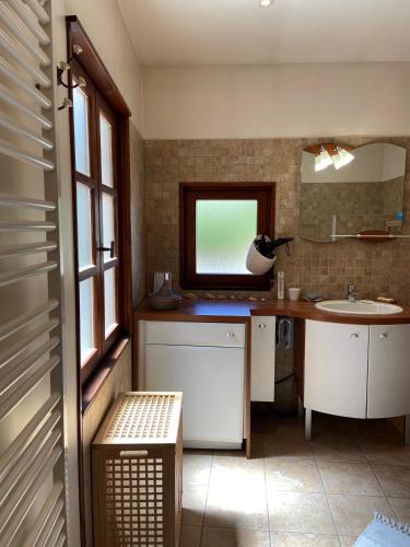 une salle de bain avec un lavabo et un miroir dans l'établissement Le Pied de Ville Pouzenc, à Embrun