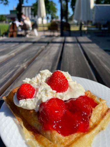 a piece of food with strawberries on a plate at Hotell Magasin 1 in Mörbylånga