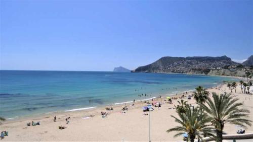 a group of people on a beach with the ocean at Calpemar Vistas panorámicas a la playa 4º piso in Calpe