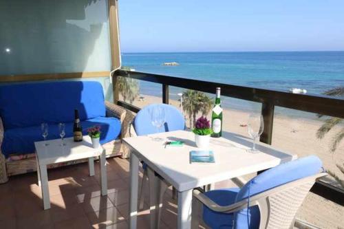 a patio with a table and chairs and the beach at Calpemar Vistas panorámicas a la playa 4º piso in Calpe