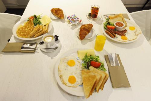 a white table with plates of breakfast food on it at Hotel CC in Amsterdam