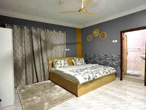 - une chambre avec un lit et un ventilateur de plafond dans l'établissement Tamani - Your home away from home, à Tamale