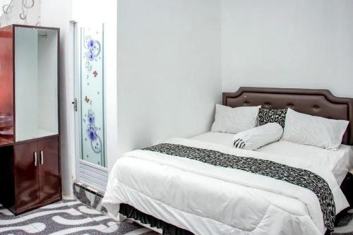 a bedroom with a bed and a dresser and a mirror at Samar Wulu Guest House Syariah Mitra RedDoorz near Ketapang in Ketapang