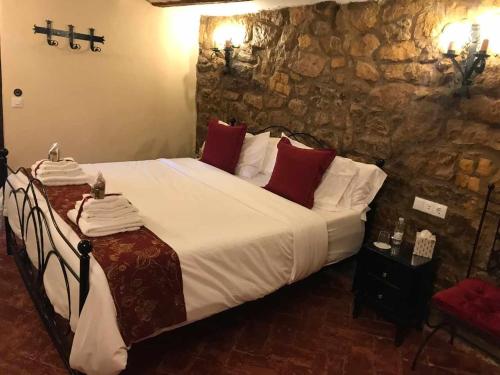 a bedroom with a large bed with white sheets and red pillows at La Posada de Leza in Laguardia