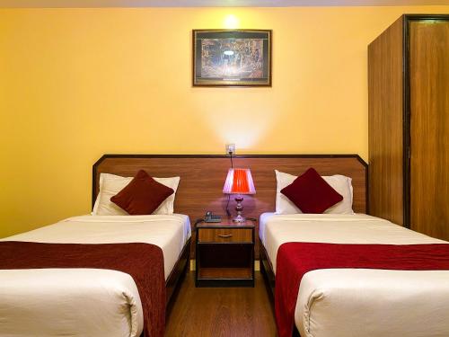 a hotel room with two beds and a lamp on a table at Thamel Grand Hotel in Kathmandu
