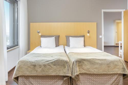 a bedroom with two beds with white sheets and pillows at Hotel Levi Panorama in Levi