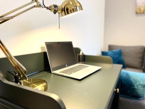 a laptop computer sitting on a desk with a lamp at T2 Hyper centre 3 étoiles Rue des Bains in Aix-les-Bains