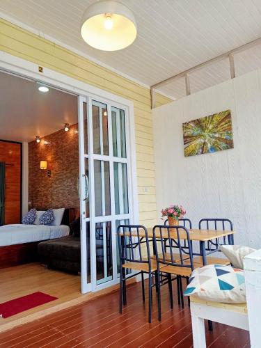 a room with a table and chairs and a bedroom at ภูฝ้ายวิลล่า Phufai villa in Chiang Khan