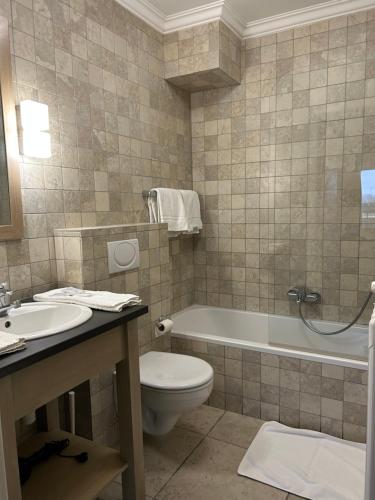 La salle de bains est pourvue de toilettes, d'une baignoire et d'un lavabo. dans l'établissement Hotel Atlas, à Zeebruges