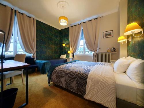 a bedroom with a bed and a desk and a room at Hotel Mondial in Tours