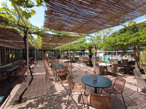 an outdoor patio with tables and chairs and an umbrella at Park Residence Il Gabbiano in Moniga