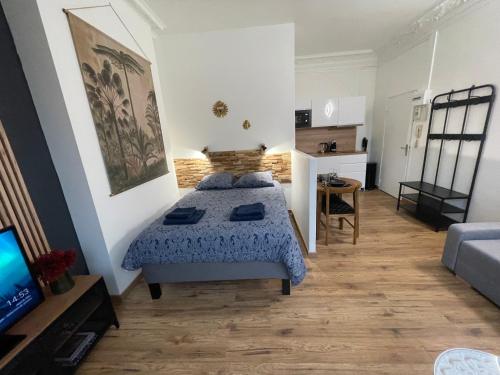 a bedroom with a bed and a living room at L'Escale Studio Arras avec parking privé in Arras