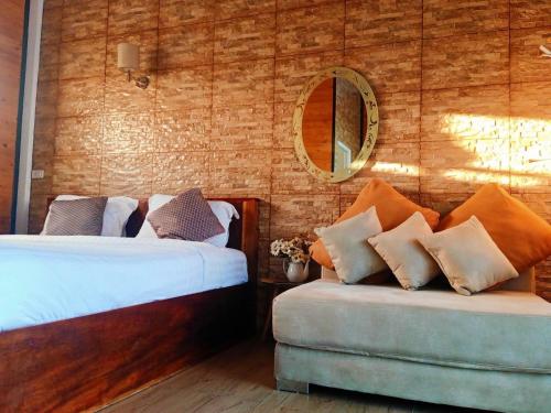 a bedroom with two beds and a couch and a mirror at ภูฝ้ายวิลล่า Phufai villa in Chiang Khan