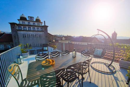 terraza con mesa de madera y sillas en el balcón en GuimaGold en Guimarães