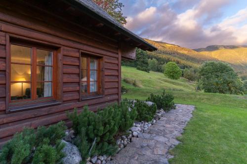 a log cabin with a stone path in front of it at Pension Slunečnice & Panorama Restaurace Farma in Špindlerův Mlýn
