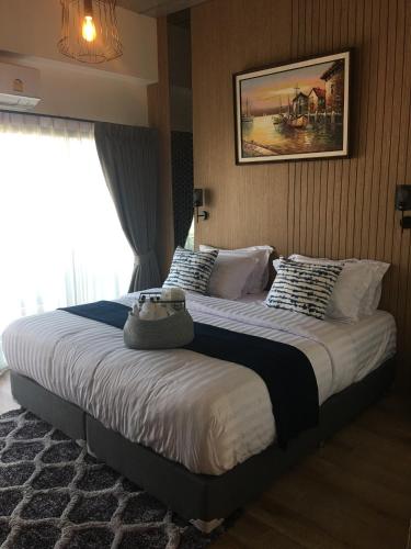 a bedroom with a large bed with a picture on the wall at Tree​ for​ rest​ poshtel in Bangkok