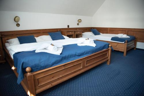 two beds in a room with towels on them at Hotel Jelinek in Špindlerův Mlýn