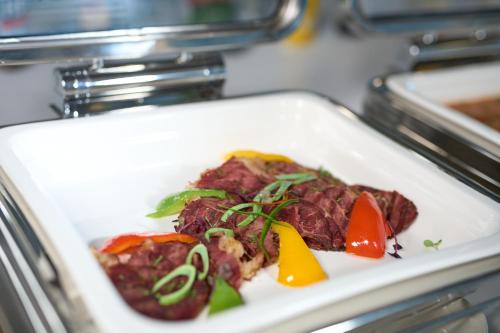 a plate of food with meat and vegetables on a table at Hotel Holiday International in Sharjah