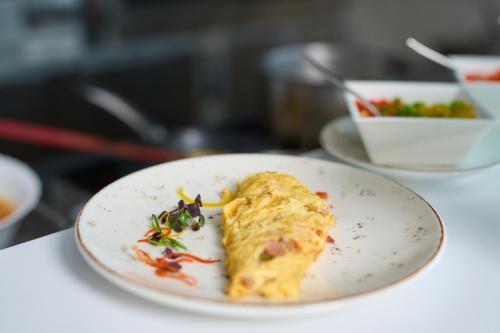a white plate with a piece of food on it at Hotel Holiday International in Sharjah