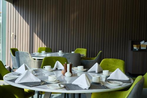 a table with plates and napkins on top at Hotel Holiday International in Sharjah